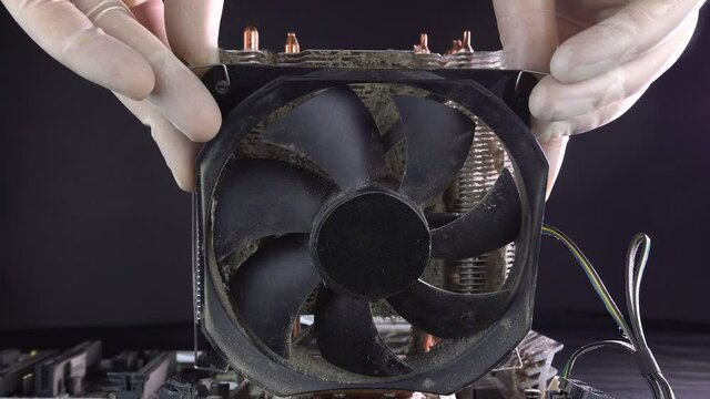 Removing the cooler from a dirty processor heatsink. Dust pollution. Cleaning the processor heat sink from dust. Close-up. 4k.