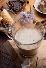 cup of coffee with sweets for coffee served at wooden tray at black wooden table. festyle concept