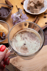 cup of coffee with sweets for coffee served at wooden tray at black wooden table. close up