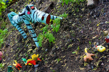 Children's toys decorate the flower bed.