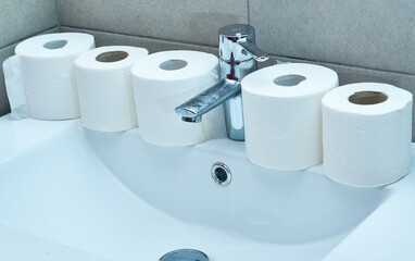Lots of toilet paper rolls on a sink. Panic concept.