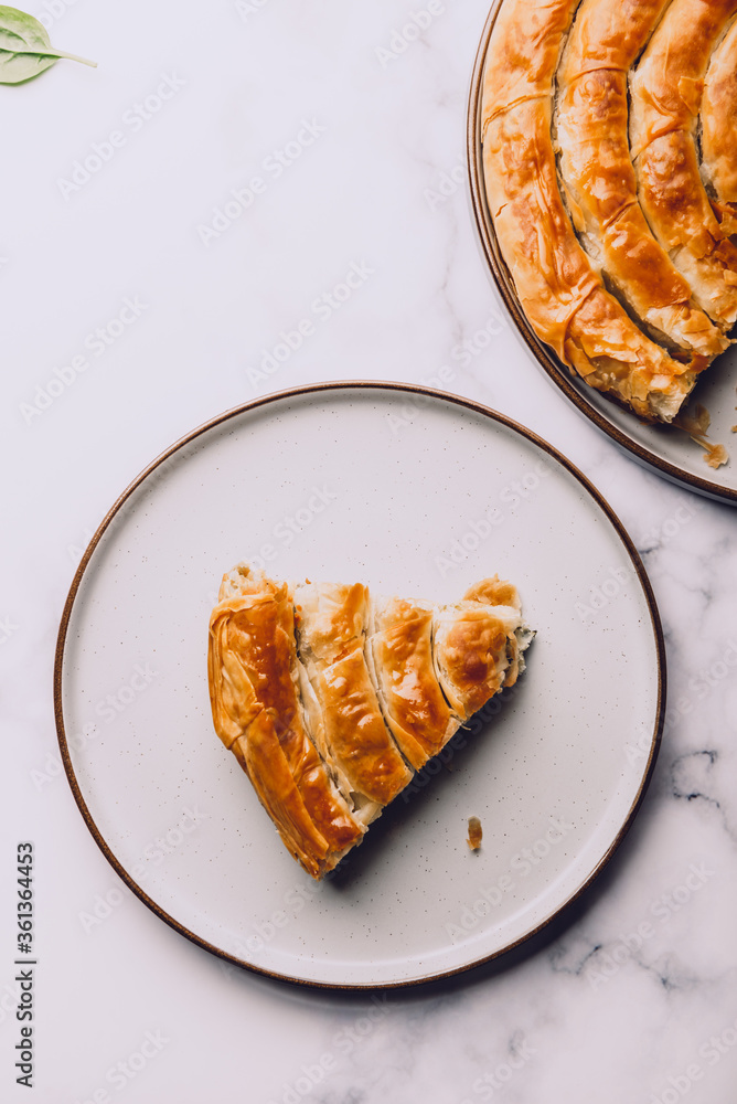 Wall mural Filo Spinach and Feta Twist Pie in the iron pan after oven. Authentic Greek bakery. With spinach, mizithra and feta cheeses.