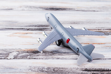 Toy plane on white wood. Close up grey model airplane.