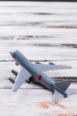 Small toy passanger plane on white wood. Close up grey airplane is turned to the left.