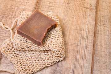 cocoa soap made from natural ingredients on a knitted washcloth, homemade soap on a wooden background, zero life-style waste, cocoa bar on a cotton thread washcloth