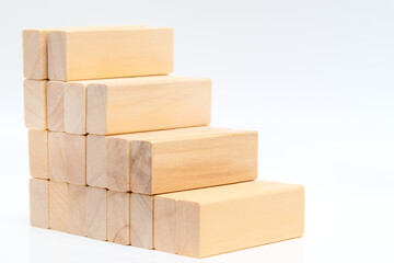 Stacking wooden blocks in shape of staircase on white background.  Ladder career path concept for business growth success process.