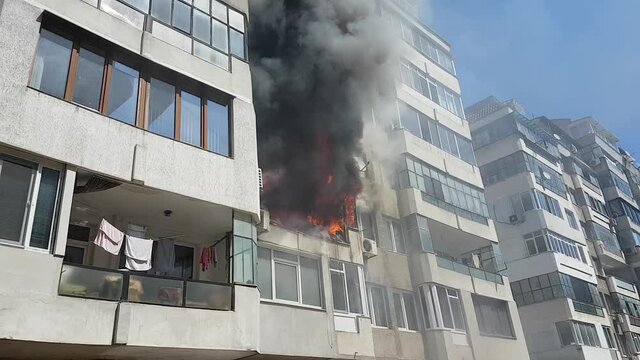 Arson or fire disaster - burning fire flame in habitable building wit apartments. Global warming heat.