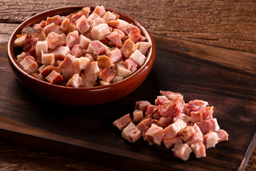closeup of cubes of bacon on a rustic wooden board. Raw - obrazy, fototapety, plakaty