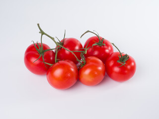 Fresh red tomatoes on a branch on a white background. Studio photography