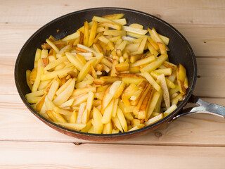 Homemade fried potatoes in a pan. A traditional dish. Frying pan of planks