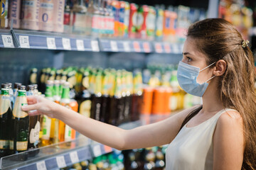 Girl in a protective mask in the store buying groceries. Life during quarantine.