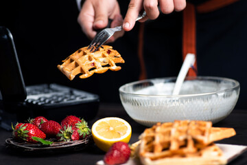 Man making waffles on a waffle machine