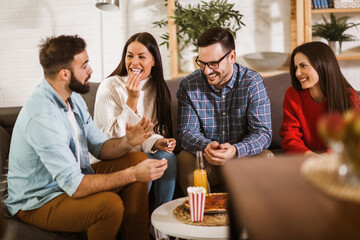 Group of young friends eating pizza in home interior.  Young people having fun together.