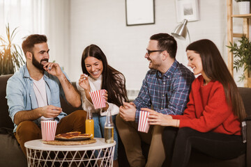 Group of young friends eating pizza in home interior.  Young people having fun together.