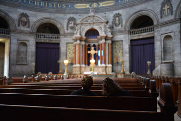 Young family sitting on bench in Catholic church