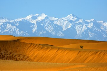 Taklamaklan Desert south side near Niya with Kunlun Mountains Snow and desert 