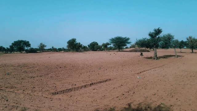 view of a field in desert areas of India with dry soil and less greenery