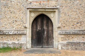 Fototapeta na wymiar Very old wooden church door with stone wall. UK