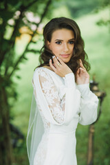 luxury stylish young bride on the background spring sunny green forest