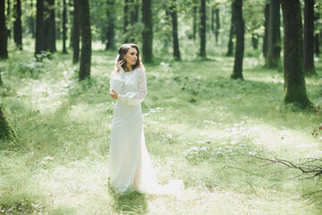 Obraz na płótnie Canvas beautiful bride in a luxurious dress in eco-style