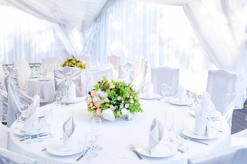 Wedding simple outdoor table setting in a white outdoor tent.