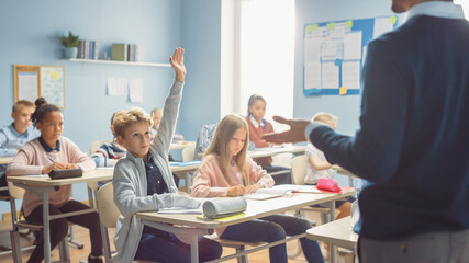 Elementary Classroom of Children Listening Attentively to their Teacher Giving Lesson. Everybody Raises Hand Knowing the Right Answer. Young Kids in School Learning Science and Creative Thinking - obrazy, fototapety, plakaty