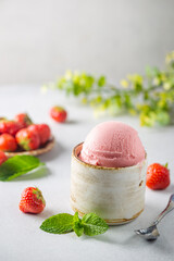 Strawberry ice cream in a bowl with fresh strawberries on white background