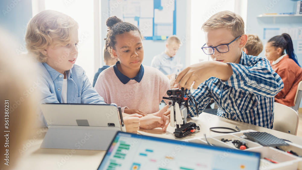 Poster elementary school robotics classroom: diverse group of children building and programming robot toget