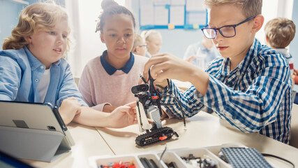 Elementary School Robotics Classroom: Diverse Group of Children Building and Programming Robot Together, Talking and Working as Team. Kids Learning Software Design and Creative Robotics Engineering