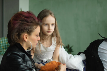 Family portrait of adult daughter, little granddaughter and senior grandfather in loft room with...