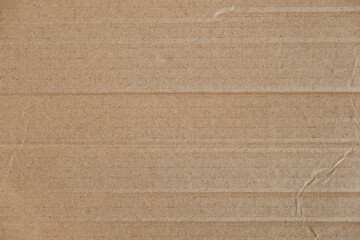 Fototapeta premium Crumpled corrugated cardboard surface texture background. Seamless crumpled brown paper textured backdrop. Top view. Copy, empty space for text