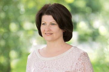 Portrait of middle aged woman with dark hair on nature