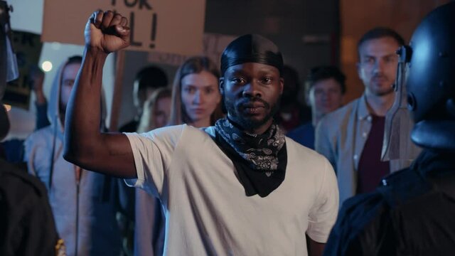 Afro-American Man Activist Raising His Fist Protesting with Young People on Demonstration For Black Lives Matter. Strike. Rebellion. No Racism. Freedom.