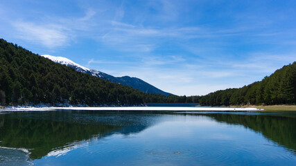Fototapeta na wymiar Hermoso lago entre montañas nevadas en un día soleado