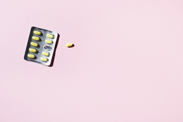 Started plate of pills with jelly shadows on a yellow background.