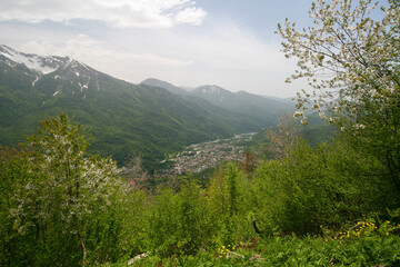 Fototapeta na wymiar View of a mountain village and the Caucasus mountains, Krasnaya Polyana, Russia.