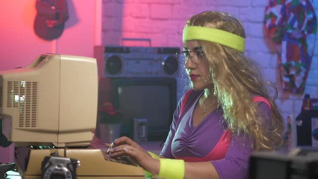 1980 1990 era style scene of a young woman working on a vintage computer typing on the keyboard. Vintage technology being used.