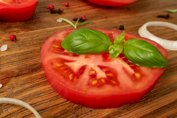 Macro photo of big tomatoe slice and fresh basil