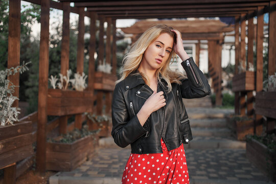 Blond young woman on red dress wild hair looking to the camera