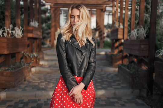 Blond young woman on red dress wild hair looking to the camera