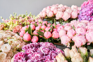 Many different colors on the stand or wooden table in the flower shop. Showcase. Background of mix of flowers. Beautiful flowers for catalog or online store. Floral shop and delivery concept. Top view