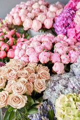 Many different colors on the stand or wooden table in the flower shop. Showcase. Background of mix of flowers. Beautiful flowers for catalog or online store. Floral shop and delivery concept. Top view