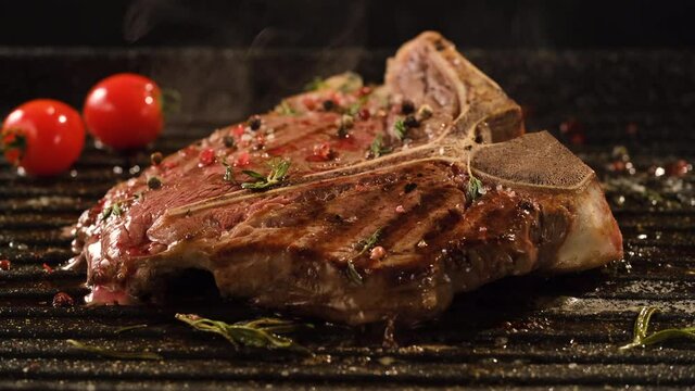 T-Bone Steak with rosemary and cherry tomatoes on the grill