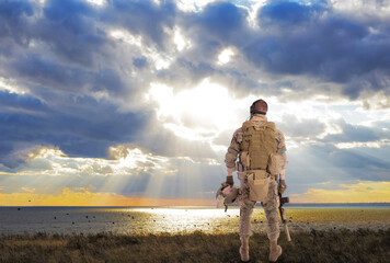 portrait of an american soldier. photographed from the back. looking into the sunset. us army