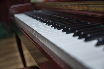 piano presses . Piano keys close up. Musical instrument . Select focus and soft focus.Close-up of a wooden piano . Defocused classic piano keyboard in white and brown colors .