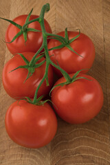 Branch with five tomatoes on a wooden board