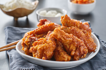 crispy fried korean chicken wings in soy garlic sauce with pickled radish and kimchi sides