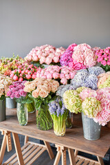 Many different colors on the stand or wooden table in the flower shop. Showcase. Background of mix of flowers. Beautiful flowers for catalog or online store. Floral shop and delivery concept. Top view