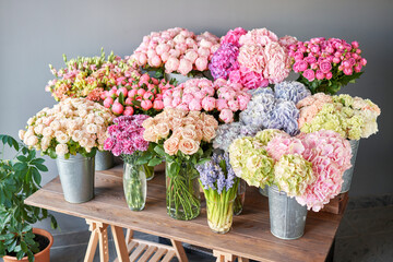 Many different colors on the stand or wooden table in the flower shop. Showcase. Background of mix...
