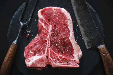 Raw T-Bone Steak with salt and pepper. Steak preparation.